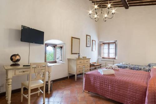 a bedroom with a bed and a desk and a table at Locanda Il Porcellum in Bagno Vignoni