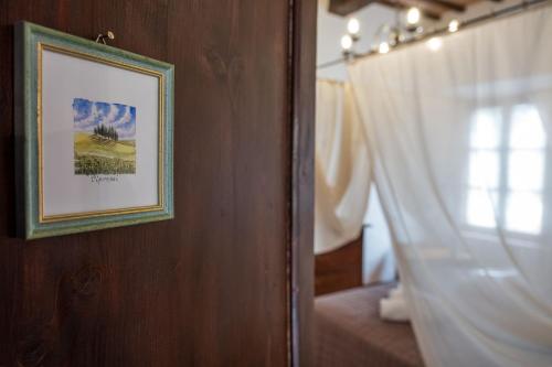 a picture hanging on a wall next to a window at Locanda Il Porcellum in Bagno Vignoni