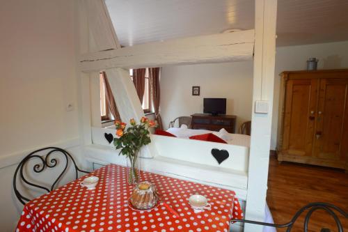 une chambre avec une table et un lit en arrière-plan dans l'établissement RIBEAUVILLE city center - Gîte des Ménétriers, LE RIESLING -, à Ribeauvillé