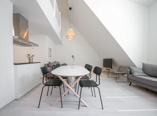 a dining room with a table and chairs and a couch at Spot Apartments Espoo Center in Espoo