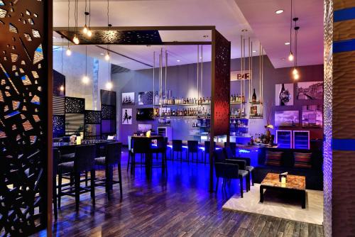 a bar with black tables and chairs and purple lighting at Radisson Blu Plaza Hotel Hyderabad Banjara Hills in Hyderabad