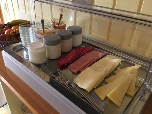 a refrigerator filled with cheese and meats and other foods at Pátio Ecolodge in Cedros
