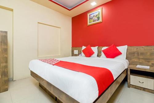 a bedroom with a large bed with a red wall at Hotel Arma Residency in Mumbai