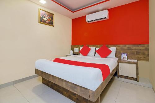 a bedroom with a bed and a red wall at Hotel Arma Residency in Mumbai