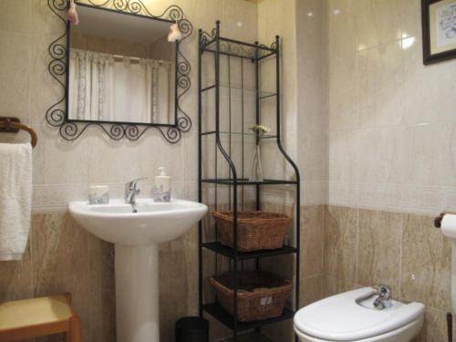 La salle de bains est pourvue d'un lavabo, d'un miroir et de toilettes. dans l'établissement El Eresma de Carmen, à Hontanares de Eresma
