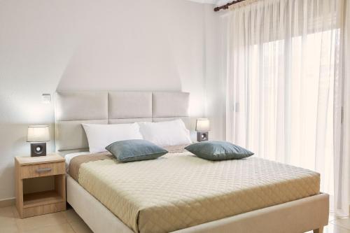 1 dormitorio blanco con 1 cama grande y 2 almohadas en Pearl Apartments, en Ofrinion