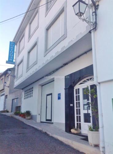 un bâtiment blanc avec une porte dans une rue dans l'établissement PORTO MAR, à Bares