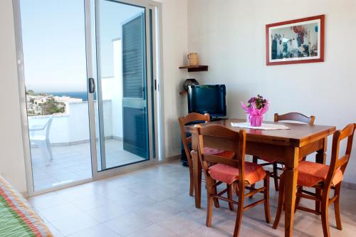 a dining room with a table and chairs and a balcony at La Torre in Santa Cesarea Terme