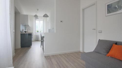 a white living room with a couch and a kitchen at La Terrazza di Casarico in Moltrasio