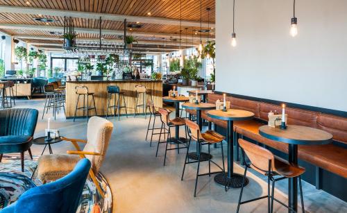 a restaurant with tables and chairs and a bar at Hotel Arena in Amsterdam