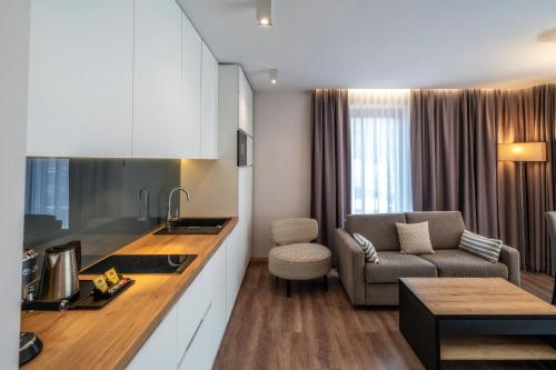 a kitchen and living room with a couch and a table at Meta Apartments in Szczyrk