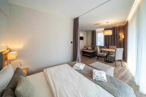 a hotel room with a bed and a dining room at Meta Apartments in Szczyrk