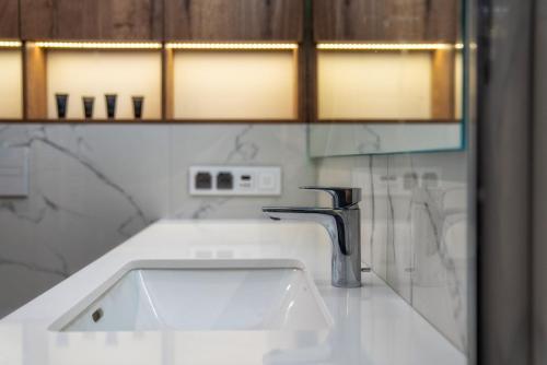 a bathroom with a sink and a faucet at Meta Apartments in Szczyrk