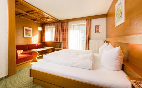 a hotel room with a bed and a couch at Tanneck Garni in Berwang