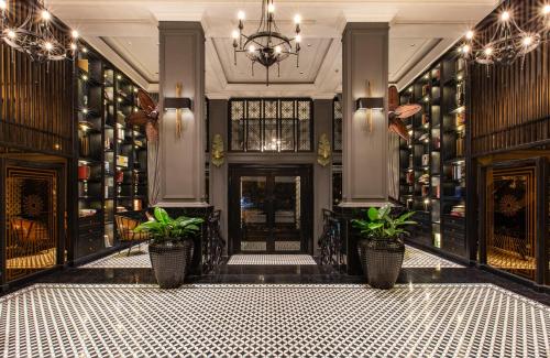 a lobby with potted plants in front of a door at La Siesta Premium Hang Be in Hanoi