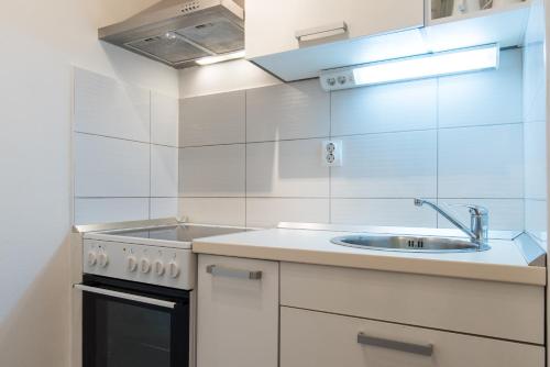 una cucina bianca con lavello e fornello di Apartments Nana a Podstrana
