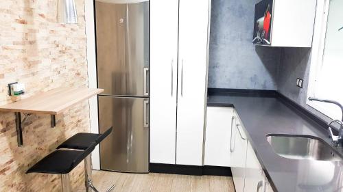 a kitchen with a stainless steel refrigerator and a table at Paseo de La Victoria in Córdoba