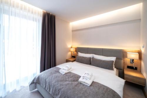 a bedroom with a large bed with two towels on it at Meta Apartments in Szczyrk