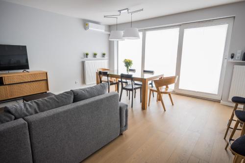 sala de estar con sofá y mesa con sillas en Easy Apartments Kielce en Kielce