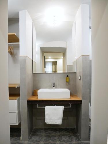 a bathroom with a white sink and a mirror at Vuciata Apartments in Catania