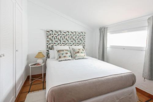 Een bed of bedden in een kamer bij Escapada Romántica en Ático frente al Mar con Piscina