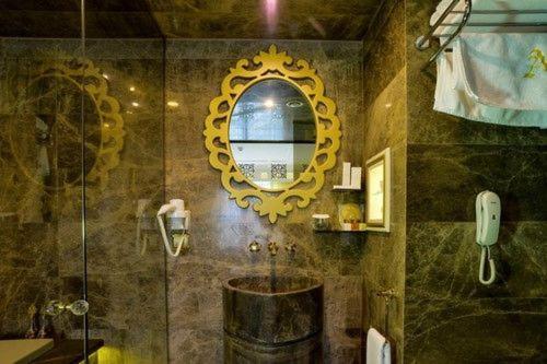 a bathroom with a mirror and a sink at Altın Otel & Spa Balıkesir in Balıkesir