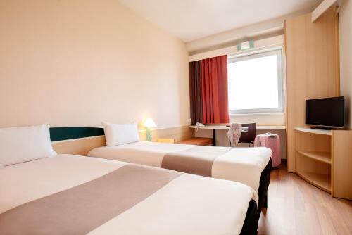Habitación de hotel con 2 camas y TV en Hotel Ibis Łódź Centrum en Lodz