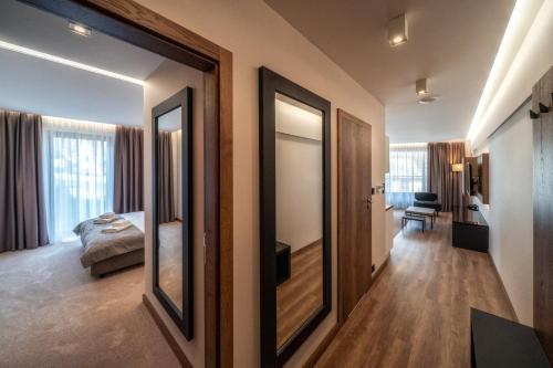 a room with a bedroom with a bed and a mirror at Meta Apartments in Szczyrk