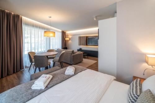 a hotel room with a bed and a dining room at Meta Apartments in Szczyrk