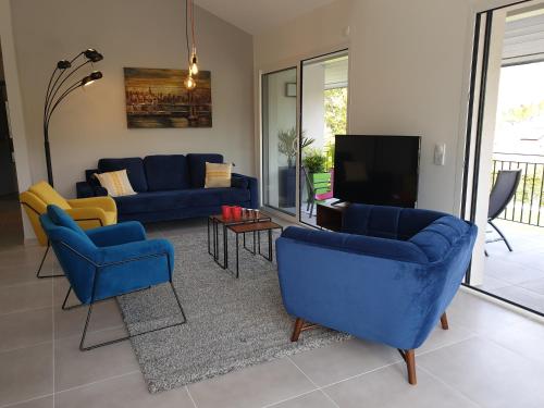 sala de estar con sillas azules y TV en Appartement Lac, en Sévrier