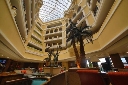 a lobby with a palm tree and a building at Welcomhotel by ITC Hotels, Devee Grand Bay, Visakhapatnam in Visakhapatnam