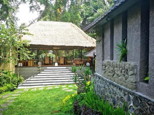 a building with a pathway leading to a gazebo at Villa with private pool at Villa Nirvana Ubud in Ubud