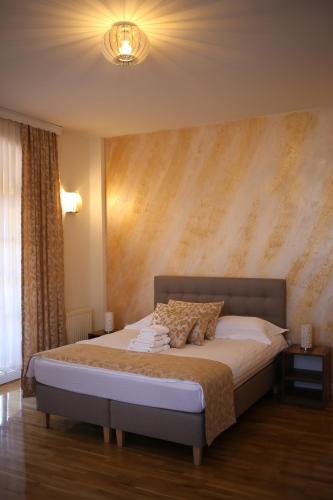 a bedroom with a large bed with a wall at Motel Vila Bakarni in Brčko