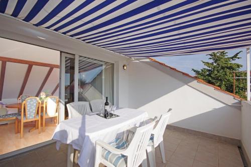 a dining room with a table and chairs on a balcony at Marija Apartments in Pirovac