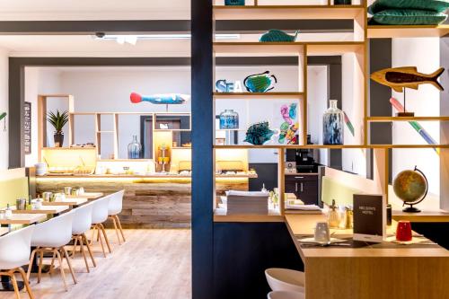 a restaurant with tables and chairs in a room at Hotel Albert Plage in Knokke-Heist
