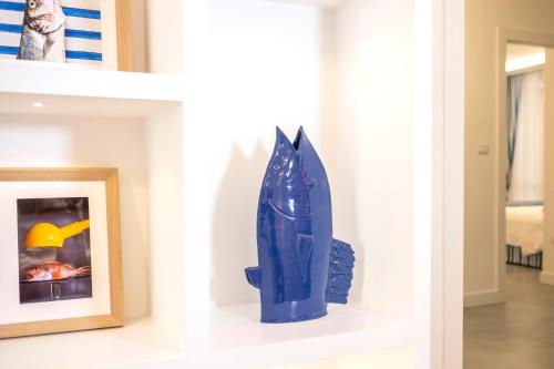 un jarrón azul sentado en un estante junto a una foto en YourHome - Unica Luxury Apartment, en Castellammare di Stabia