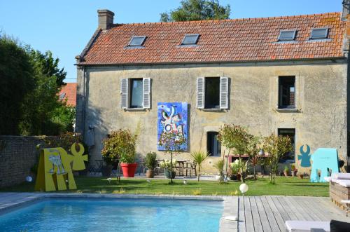 une maison avec une piscine devant dans l'établissement Ô Grenier de l'artiste, à Bazenville