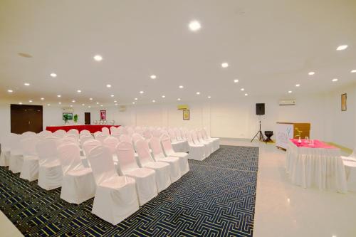 a room with rows of white chairs and a stage at Hotel Clarks Collection Bhavnagar in Bhavnagar