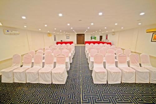 a room with rows of white chairs in a hall at Hotel Clarks Collection Bhavnagar in Bhavnagar
