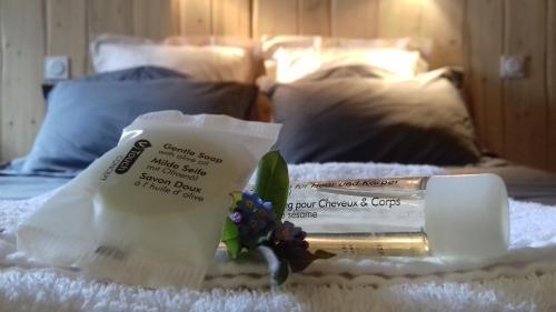 a bed with a bottle of soap and flowers on it at Chalet Le Bois Joli in Bonneval-sur-Arc