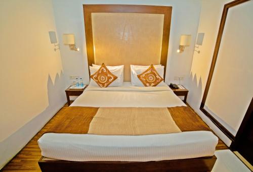 a bedroom with a large bed with two night stands at Hotel Clarks Collection Bhavnagar in Bhavnagar