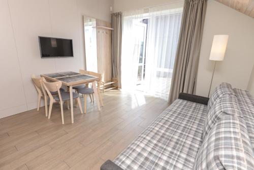 a living room with a bed and a table with chairs at Vila Paula in Palanga