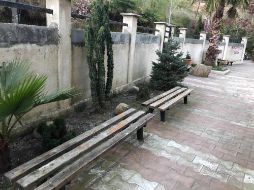 a wooden bench sitting next to a fence at Guest House Lasha in Mtsvane Kontskhi