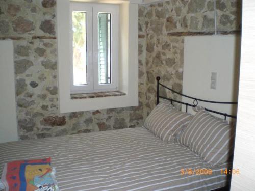 a bedroom with a bed with a window at Sofia Apartments in Paralía Iríon