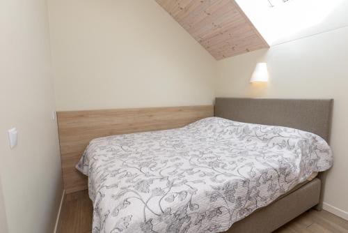 a bedroom with a bed in a white room at Vila Paula in Palanga