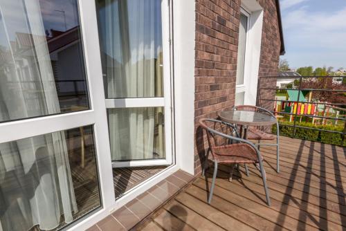 a patio with a table and chairs on a balcony at Vila Paula in Palanga