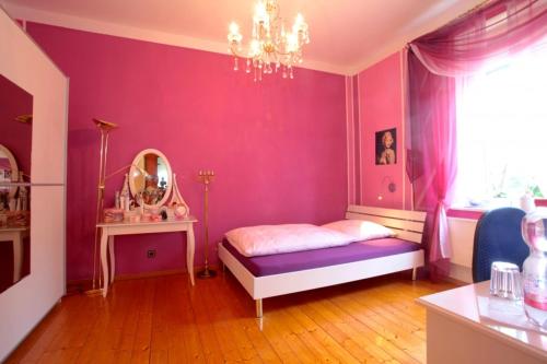 a pink bedroom with a bed and a mirror at Private Rooms in Hannover