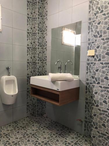 a bathroom with a sink and a urinal at Villa Bunmark in Sirindhorn