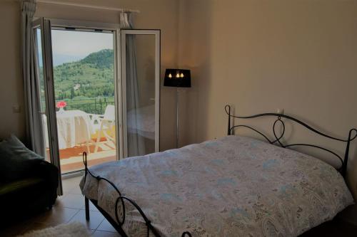 a bedroom with a bed and a sliding glass door at Ermina's gaze in Áyioi Dhéka