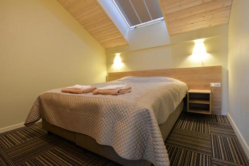 a bedroom with a bed with two towels on it at Vila Paula in Palanga